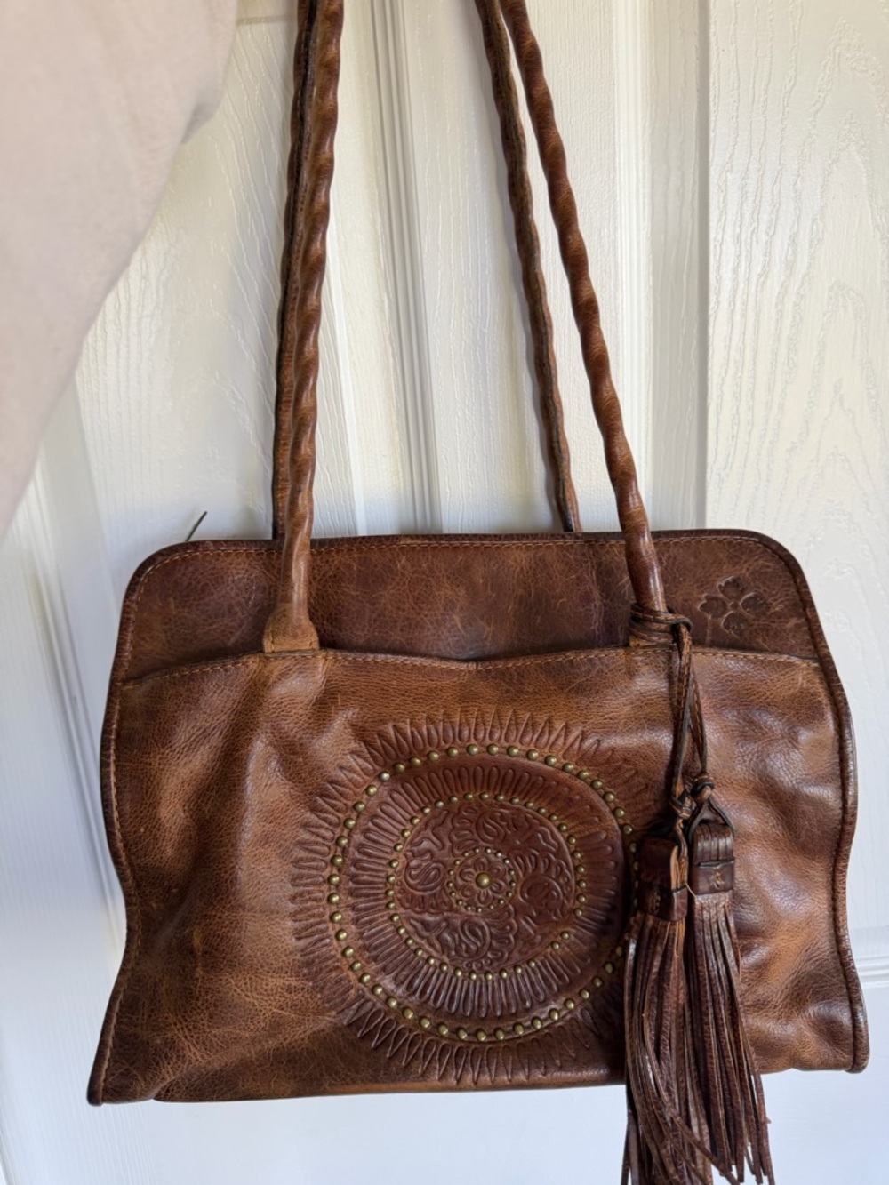 Brown Leather Tote Bag with Embossed Medallion and Tassel
Patricia Nash